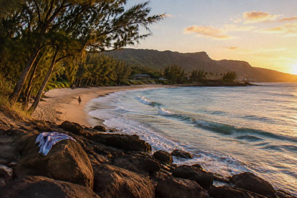 A sandy Hawaii beach with gentle waves and no people in the water