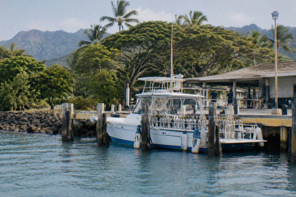 A moored dive boat at a small boat harbor on Oahu on a clear morning