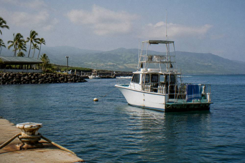 A boat anchored in deep blue water far from the Oahu coastline