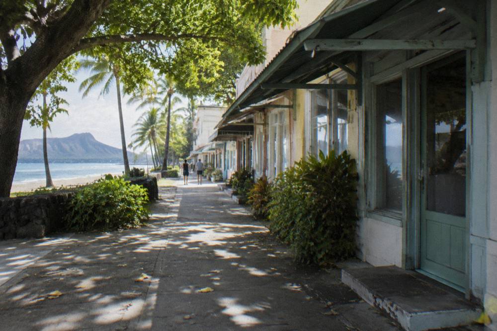 A historic Honolulu street with older buildings and leafy trees