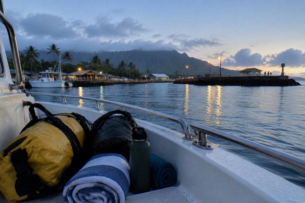 Dry bags and towels packed on a charter boat deck before departure