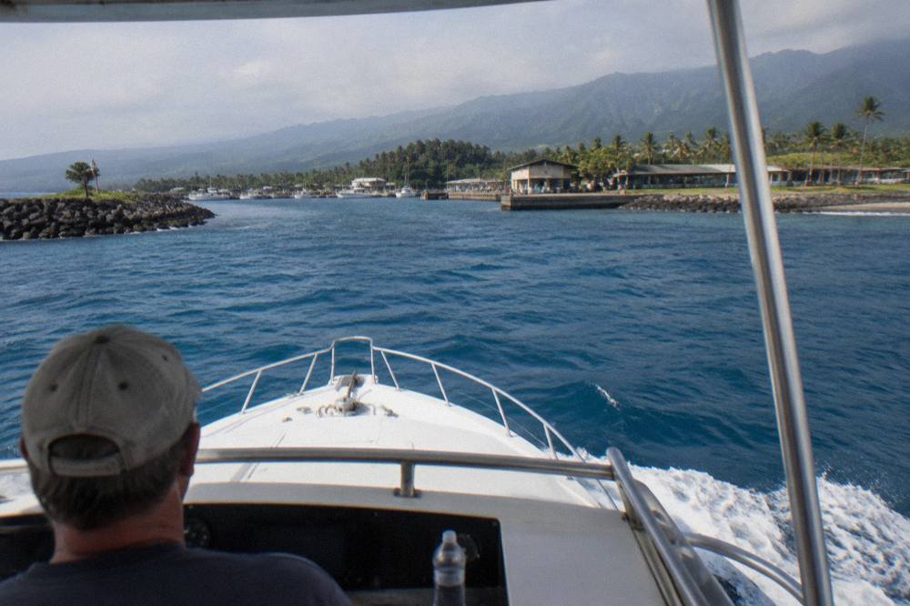 A dive boat cruising over deep blue open water off the North Shore of Oahu