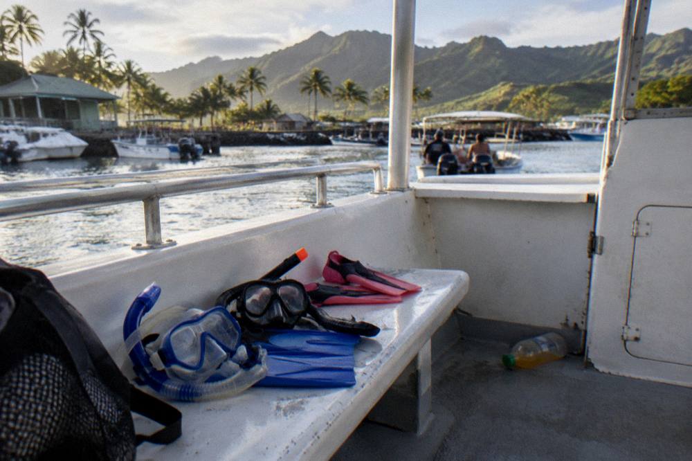 A family preparing snorkel masks on the deck of a tour boat