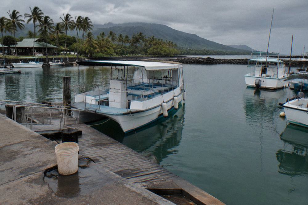 Boat docked at a small boat harbor with calm water and moored vessels
